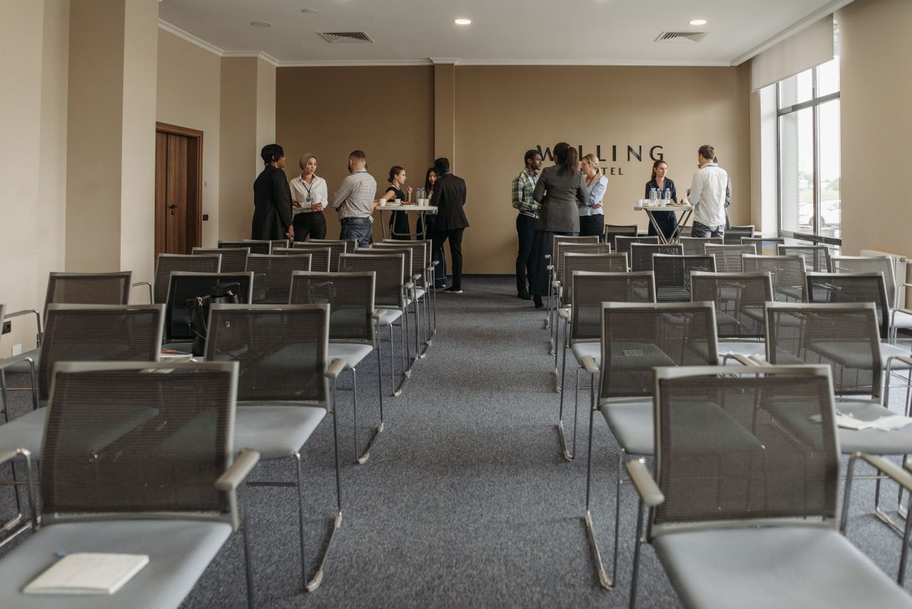 Rows of seating in a lecture hall with a small group talking.